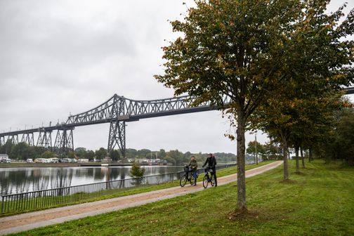 Rensburger Hochbrücke mit zwei Radfahrern im Vordergrund.