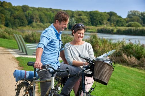 Radfahrer schauen an der Stör bei Itzehoe auf eine Karte