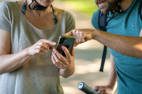 Zwei Radfahrer planen Ihre weitere Radtour auf dem Handy