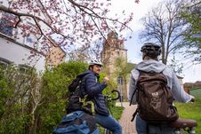 Paar steht mit Fahrrädern vor der Vicelinkirche in Neumünster.