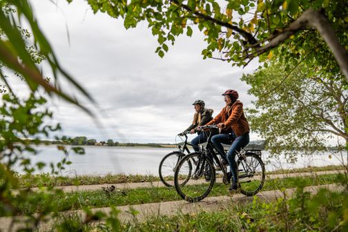 Zwei Freundinnen fahren auf dem Ochsenweg an der Schlei.