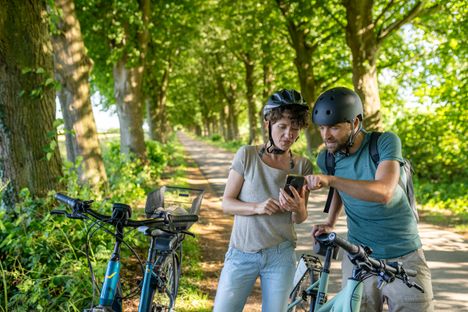 Paar macht eine kurze Pause auf dem Ochsenweg, um sich zu orientieren mit dem Handy. 