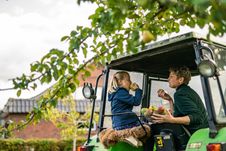 Mutter und Tochter essen Äpfel auf dem Trecker. 