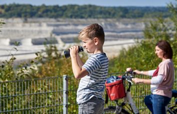 Junge schaut mit seinem Fernglas in die Natur.