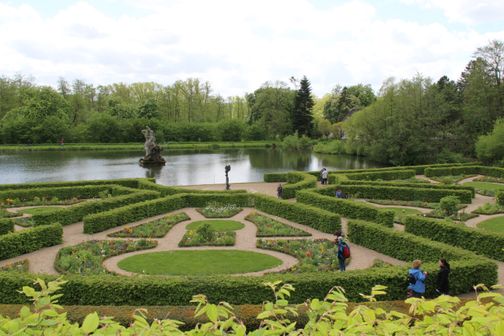 Menschen spazieren durch den Barockgarten im Schloss Gottorf